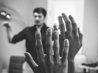 Close up of two raised hands in an audience